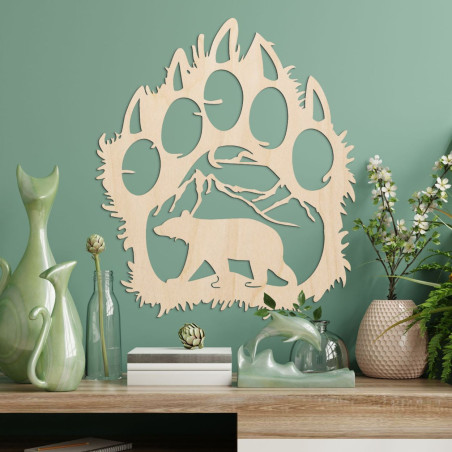 O siluetă contrastantă a unei cărări de urs, în interiorul căreia se poate observa un lanț muntos și figura unui urs care merge 