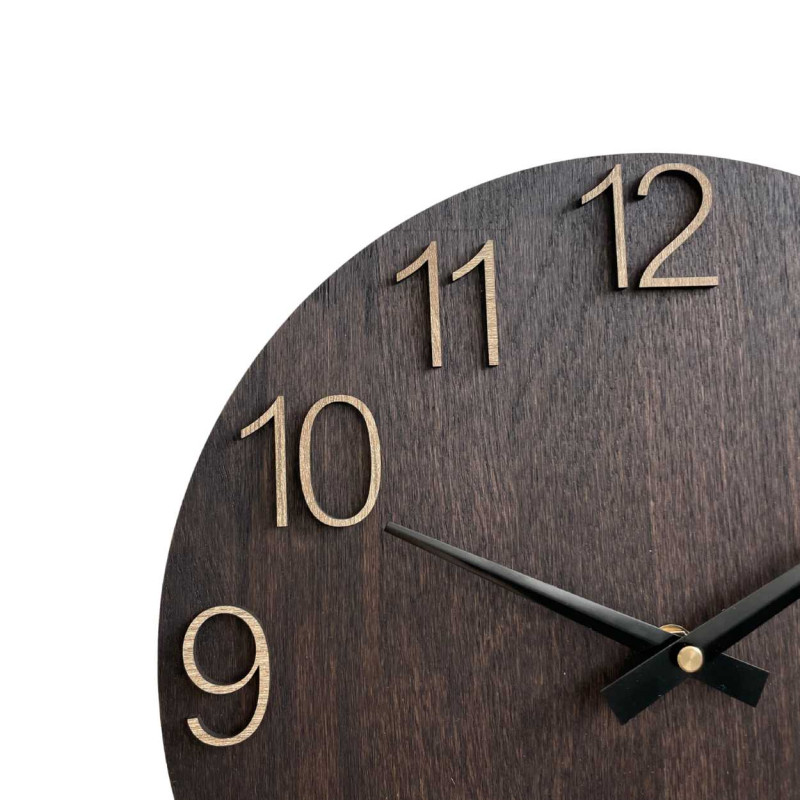 Ceas de perete din lemn cu cifre sculptate și ace metalice.