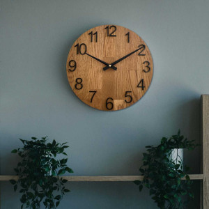 Ceas din lemn sculptat, cu cadran simplu și design minimalist.