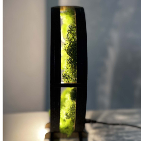 O vedere de aproape a unui Copac al Vieții din lemn, iluminat din spate, înconjurat de mușchi.