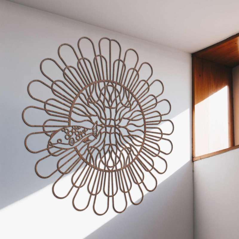 Mandala din lemn negru cu pește pe un perete alb într-un apartament modern