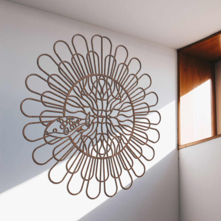 Mandala din lemn negru cu pește pe un perete alb într-un apartament modern