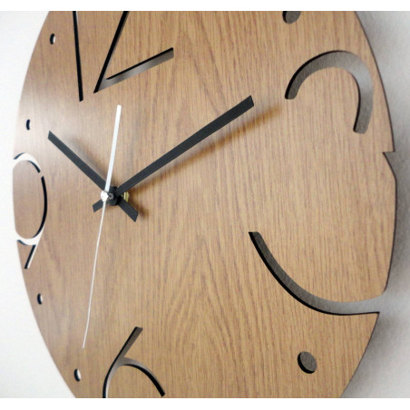 Ceas rotund din lemn cu numere sculptate 3, 6, 9 și 12 pe o bază din stejar deschis la culoare. Ceas rotund din lemn cu numere sculptate 3, 6, 9 și 12 pe o bază din stejar deschis la culoare.